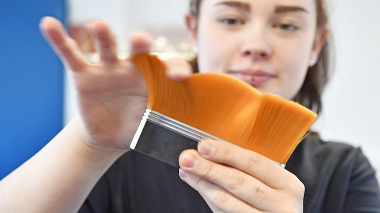 Michelle Müller streicht über einen Pinselkopf. Soeben hat sie die Pinselhaare in der Metallzwinge befestigt.  Fotos: Ronald Rinklef