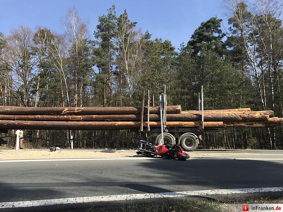 Motorradfahrer rutscht unter Lastwagen