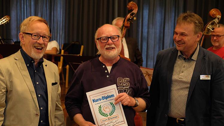 Als gewissermaßen alter Hase wurde Kurt Brückner für seine 25-jährige Teilnahme an den Pfingstkursen geehrt. Hier mit Präsident Joachim Kaiser (rechts) und Kuno Holzheimer, dem musikalischen Leiter der Musikakademie.  Foto: Gerd Schaar