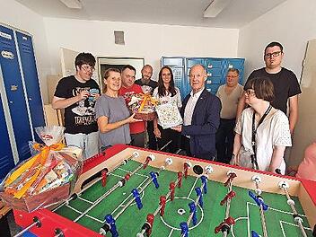 Roland Pfister übergibt den Kicker an Betreuer und Mitarbeiter der Lebenshilfe Forchheim.