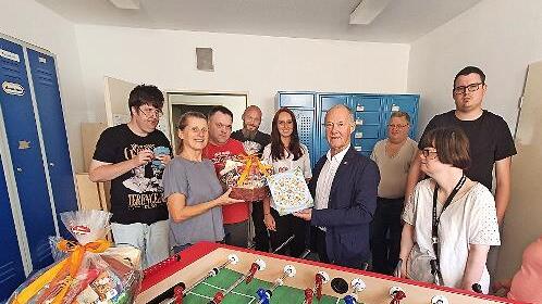 Roland Pfister übergibt den Kicker an Betreuer und Mitarbeiter der Lebenshilfe Forchheim.