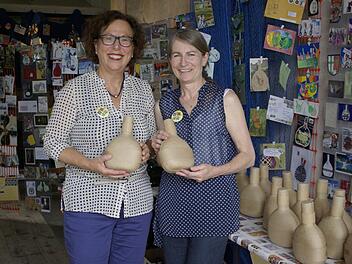 Barbara Stross und Andrea Mohr (v. l.) mit dem "Memory" der "mail-art-Bocksbeutel"-Ausstellung, dem Pappe-Bocksbeutel inklusive Überraschung. Foto: Winfried Ehling