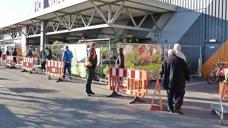Die Kunden werden entlang von Absperrgittern in Sicherheitsabstand in den Baumarkt gelassen.   Fotos: Julian Megerle