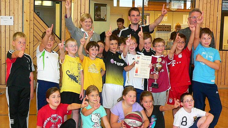 Als Sieger des abschließenden Wurfwettbewerbs bekam die Nordhalbener 4. Klasse einen Pokal von Marketing-Leiterin Karin Elsel (hintere Reihe, links) von der Raiffeisen-Volksbank Kronach-Ludwigsstadt und Brose Baskets-Koordinator Sebastian Böhnlein (hintere Reihe, Mitte) sowie Schulamtsdirektor Uwe Dörfer (hintere Reihe, rechts).(+ Fotos für online-Bilderstrecke).