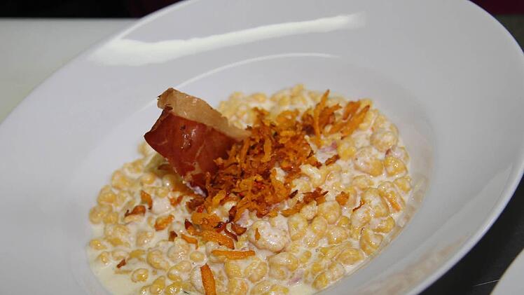 Besonders appetitlich sieht die Südtiroler Spezialität aus, wenn der Teller mit frittierten Kürbisstreifen und einer kross gebratenen Scheibe Bauchspeck garniert wird. Foto: Sonja Adam