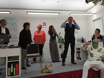 Beamter Theo (Tobias Engel, Fünfter von links) hat Visionen  - da staunen der Unternehmensberater (Wolfgang Stark), die Bürgermeisterin (Annette Klinke), Karla Gutknecht (Beate Lamm), Wahrsagerin Esmeralda (Christiane Scheer) und Kollegin Elfriede (Cornelia Lurtz, ganz rechts). Ganz vorne sitzt der Geist Nikolaus (Norbert Dietz). Foto: Monika Schütz