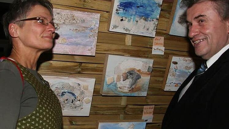 Edina Thern zeigt Bürgermeister Siegfried Beyer ihre Muschelspiele: Die Muschlen stammen aus ihrer alten Heimat Florida, der Sand ebenfalls.