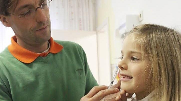 So  könnte eine Grippeimpfung ohne Spritze  aussehen: Der Impfstoff für Kinder wird  in die Nase gesprüht. Kinderarzt Patrick Muzzolini zeigt bei der siebenjährige Marlene, wie es aussehen könnte.   Foto: Vanessa Schneider