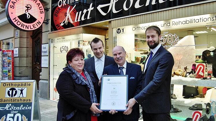 Monika, Michael und Günter Hörnlein (von links) überreichte Sascha Genders von der IHK (rechts) die Urkunde zum 50-jährigen Bestehen des Sanitätshauses Hörnlein in Bad Kissingen.  Foto: Sigismund von Dobschütz
