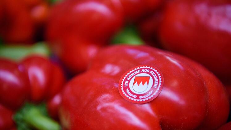 Auf einer frisch geernteten Paprika des Gemüsebaubetriebes "Scherzer und Boss" ist der Aufkleber mit der Aufschrift "Ich komme aus Franken" zu sehen.  Foto: Nicolas Armer/dpa