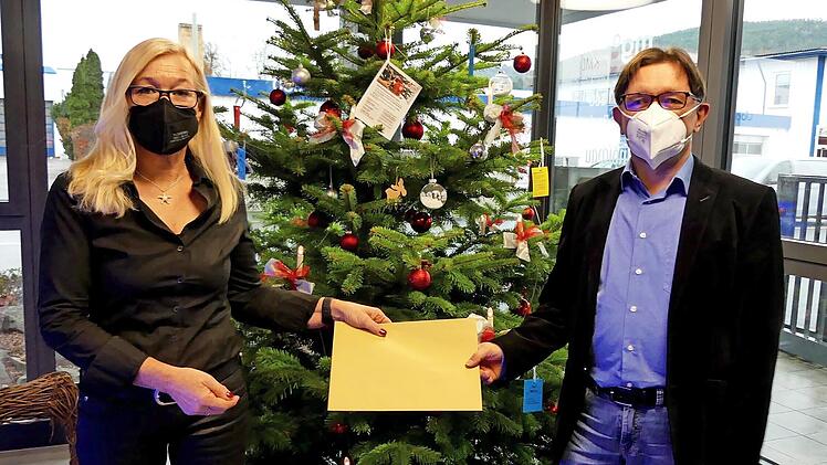 Helga Kauper, Zweite Vorsitzende der SG Biathlon Stadtsteinach, übergibt die Startgelder des 16. Hainberglaufs an BR-Redaktionsleiter Alexander Müller.