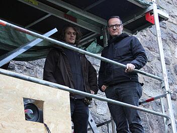 Raphael Schardt und Rotary-Präsident Rolf Hering in luftiger Höhe auf dem Gerüst im Wallgraben. Mit einem Hochleistungsbeamer, der sich in der Holzkiste befindet, wird die Videoprojektion "Sturm auf Kronach" an die Wallmauer gestrahlt.  Fotos: Friedwald Schedel