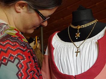 Tina Vadász-Hain hängt ihr selbst gefertigtes Kleid zurecht. Es entspricht der Gewandung des Bürgertums in der Zeitspanne um etwa 1500 bis 1530. Foto: Marco Meißner