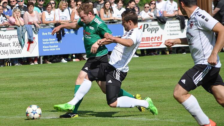DJK-SV Neufang - SC Jura Arnstein: Markus Wunder (weißes Trikot) kann mit einem langen Bein den Vorstoß des Arnsteiners Johannes Wachter gerade noch stoppen. Foto: Herbert Kalb