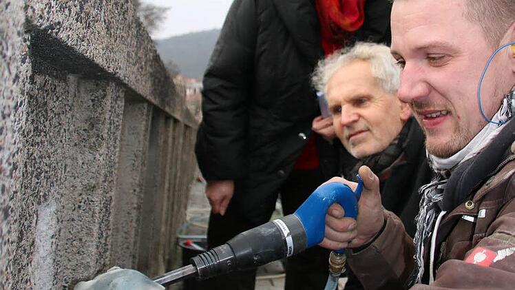 Steinmetz Christopher Stark (vorne) von der Firma Kleese stemmt den schadhaften Beton ab, Christel Fuchs und Erwin Full vom Staatlichen Bauamt schauen ihm dabei über die Schulter. Foto: Ralf Ruppert