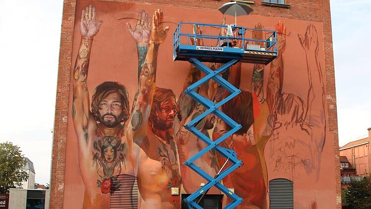 Männliche Person, sich drehend, aus fünf Perspektiven: Derzeit arbeitet  Street-Art-Künstler Case Maclaim an einem imposanten Wandgemälde in Erlangen.  Foto: Christian Bauriedel