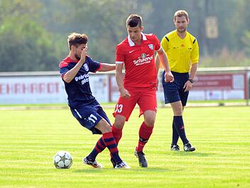 Felix Burkel (rotes Trikot) spitzelt den Ball an einem Höchberger vorbei. Schiedsrichter Johannes Angele hat alles im Blick. Fotos: herzopress