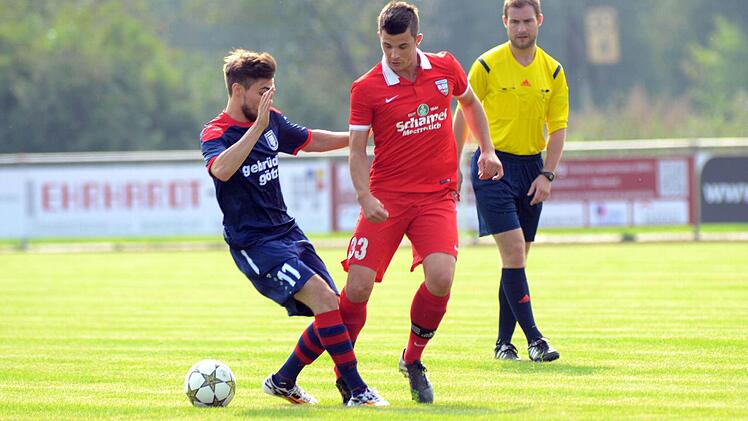 Felix Burkel (rotes Trikot) spitzelt den Ball an einem Höchberger vorbei. Schiedsrichter Johannes Angele hat alles im Blick. Fotos: herzopress
