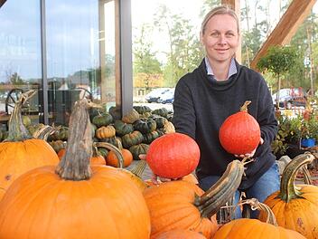 Kathrin Güthlein zeigt die Vielfalt der Kürbisse - der Pilatushof bietet unter anderem rote Hokkaido, grüne Muskatkürbisse und orangefarbene Halloween-Kürbisse aus eigenem Anbau an. Foto: Ronald Heck