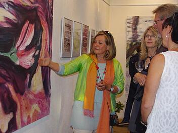 Andrea Partheymüller-Gerber (links) erläutert den Gästen ihr Pflanzenfarbbild "Malve". Fotos: Heike Schülein