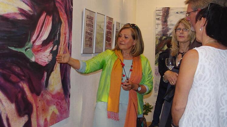 Andrea Partheymüller-Gerber (links) erläutert den Gästen ihr Pflanzenfarbbild "Malve". Fotos: Heike Schülein