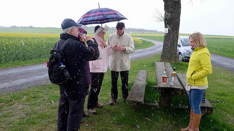 Bei einsetzendem Schneegestöber gab es Franziska Bischofs Informationsvortrag über den Rhöner Whisky am Dreimärker-Kreuz. Die Wanderer ließen sich nicht vom Besuch abhalten und erhielten zur Belohnung einen Schluck aus dem Probierglas. Foto: Gerd Schaar