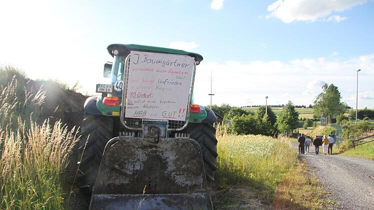 Vor der Festhalle war der Traktor mit der Aufschrift "Jürgen Baumgärtner vernichtet unser Eigentum Wald und bringt Unfrieden in unsere Region. 10. Gebot: Du sollst nicht begehren deines Nächsten Hab und Gut!" steht auf dem Schild. Foto: Sonny Adam