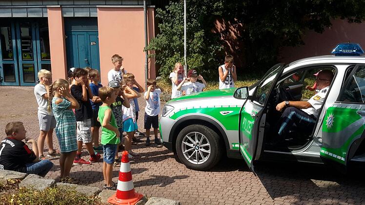 Spontan halten sich die Kinder ihre Ohren zu, als Polizeihauptkommissar Manfred Schneider (im Streifenwagen) das Martinshorn erklingen lässt. Denn aus kurzer Distanz geht das laute Einsatzsignal doch mächtig aufs Trommelfell.Rolf Pralle