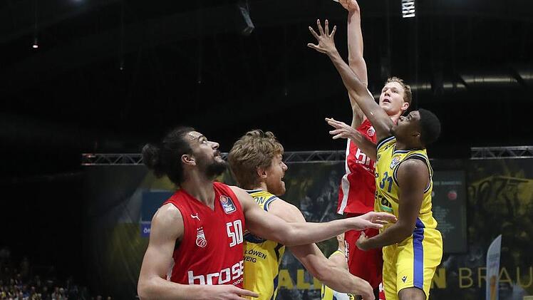 Mit einem Hakenwurf über den Braunschweiger Joseph Lawson hinweg versucht Christian Sengfelder (hinten) zu punkten. Vorne ringen die beiden Center Assem Marei und Scott Eatherton um die bessere Position für den Rebound. Foto: Susanne Hübner