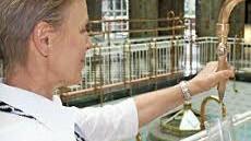 Brunnenfrau Regina Schiebelbein zapft das Wasser. Foto: Mäuser