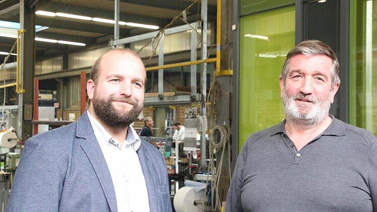 Sohn Jan und Vater Michael Pazdera in der Coburger Fertigungshalle. Im Hintergrund ein Musterfassadenteil. Foto: Simone Bastian