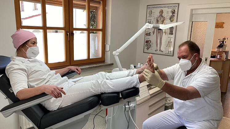 Unter den strengen Blicken seiner Frau nimmt Dirk Prosch ihren Fuß ins Visier. Über 520 Praxisstunden hat er schon im heimischen "Fußglück" in Großwalbur absolviert.