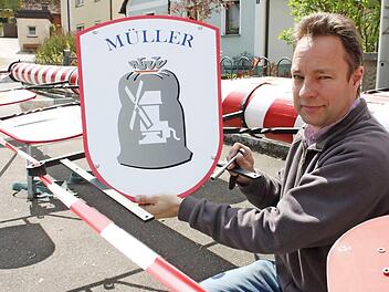 Matthias Richter beim Anbringen einer Zunfttafel an dem etwa 18 Meter langen, rot-weißen Zunftbaum. Foto: Popp