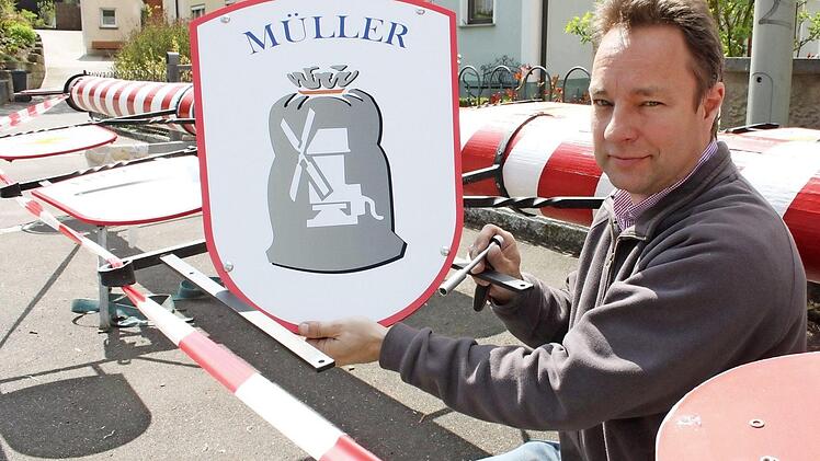 Matthias Richter beim Anbringen einer Zunfttafel an dem etwa 18 Meter langen, rot-weißen Zunftbaum. Foto: Popp