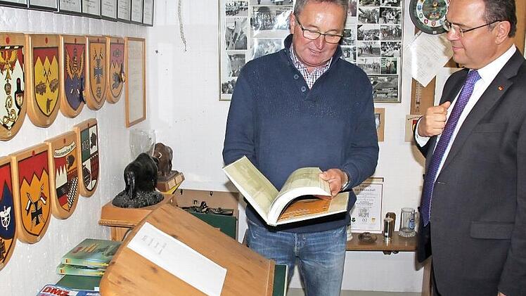 Museumsführer Willi Kleinlein zeigte dem Gast aus Hof viele Details, wie auch die Chronik der Panzeraufklärer. Foto: Ralf Kestel