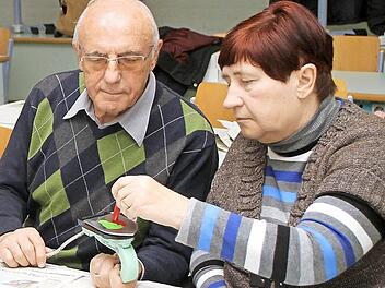 Günther Schnabel hält das Mal-Eisen, während seine Frau Gerda die Farben auf die heiße Fläche aufträgt. Foto: Günther Geiling