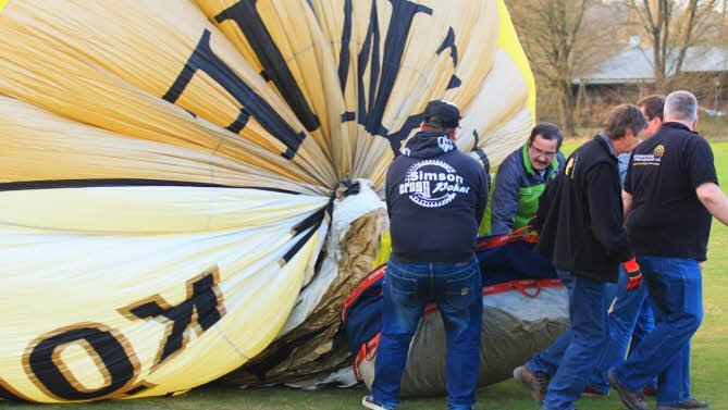 Während Kaltluft in die Hülle strömt sorgen kräftige Männer dafür, dass sich die Haut des Ballons nach und nach exakt entfaltet.