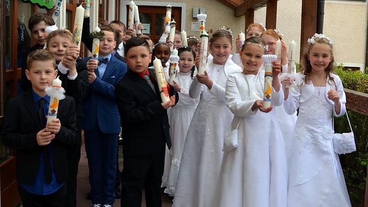 Stolz zeigten die Strullendorfer Erstkommunionkinder ihre selbst gestalteten Kerzen, die sie für ihre Erstkommunion-Feier angefertigt haben. Foto: Andrea Spörlein