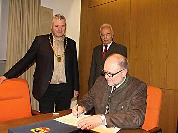 Meist blickte er als Bürgermeister über die Schulter von Personen die sich in das Goldene Buch der Stadt Ebern eintrugen. Am Donnerstag durfte er sich als Altbürgermeister selbst im Goldenen Buch verewigen. Robert Herrmann beim Eintrag, beobachtet von Bürgermeister Jürgen Hennemann (links) und Franz Geuß, dem die gleiche Ehre zuteilwurde wie Altbürgermeister Robert Herrmann. Foto: Helmut Will