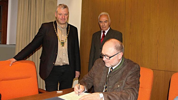 Meist blickte er als Bürgermeister über die Schulter von Personen die sich in das Goldene Buch der Stadt Ebern eintrugen. Am Donnerstag durfte er sich als Altbürgermeister selbst im Goldenen Buch verewigen. Robert Herrmann beim Eintrag, beobachtet von Bürgermeister Jürgen Hennemann (links) und Franz Geuß, dem die gleiche Ehre zuteilwurde wie Altbürgermeister Robert Herrmann. Foto: Helmut Will