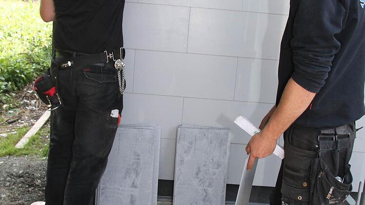 Mark Trapper und Alexander Schuberth verkleiden das Schützenhaus mit Faserzementplatten.