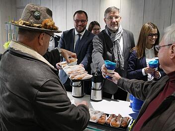 Zur offiziellen Einweihung des Bürgerservices überreichen Landrat Sebastian Straubel  (CSU) und sein Vorgänger Michael Busch (SPD)  Kaffee und Krapfen an die Besucher. Foto: Jutta Rudel
