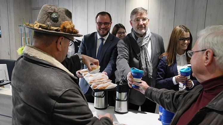 Zur offiziellen Einweihung des Bürgerservices überreichen Landrat Sebastian Straubel  (CSU) und sein Vorgänger Michael Busch (SPD)  Kaffee und Krapfen an die Besucher. Foto: Jutta Rudel