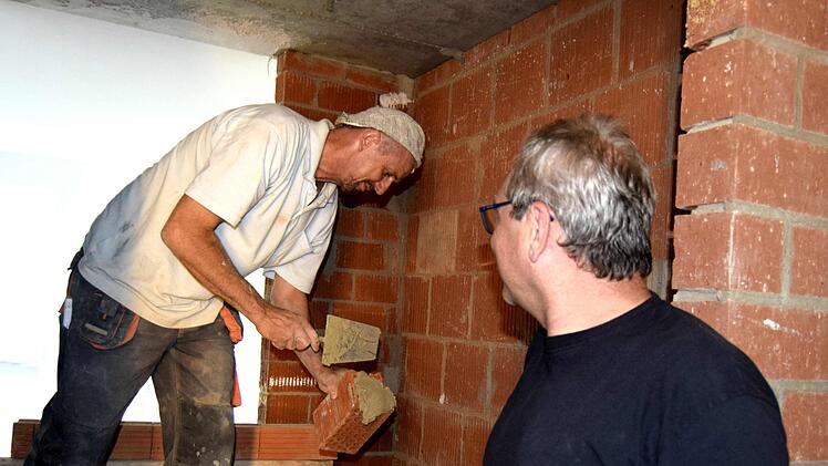 Erwin Marx mauert die Türsturzauflagen, Vorarbeiter Markus Eck (rechts) reicht ihm zu.  Foto: Andreas Welz