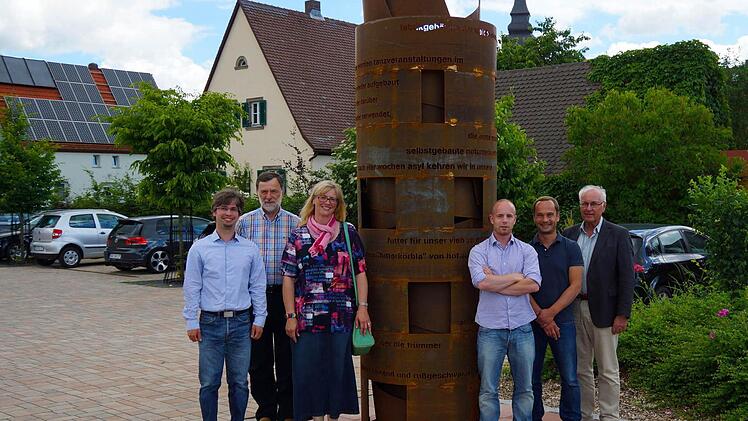 Die Hauptbeteiligten an der Neuauflage stellten sich am Mahnmal auf (von rechts): Baptist Schütz, Matthias und Tobias Christian (Layout), Bettina Betz (Texte und Lektorat) sowie Johannes Michel (links außen, Bildbearbeitung, Texte, Internet). Links hinten: Bürgermeister Josef Martin.