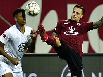 F&uuml;r Abwehrspieler Robert Bauer (rechts, hier im Duell mit dem Wolfsburger Felix Uduokhai) ist der Kampf des 1.&nbsp;FC N&uuml;rnberg um den Klassenerhalt noch l&auml;ngst nicht gelaufen. Foto: Archiv