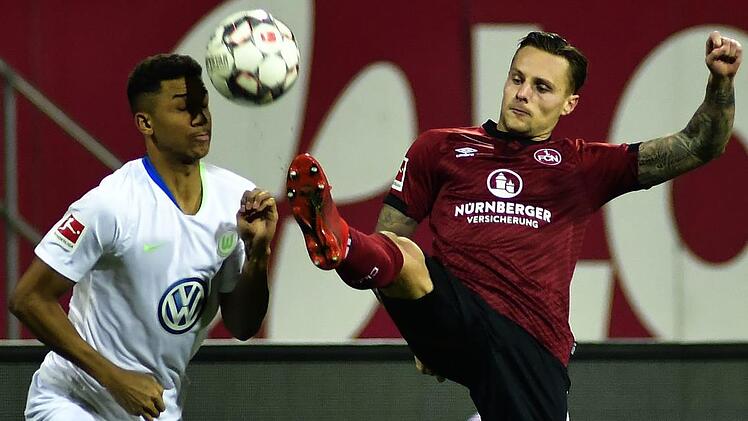 F&uuml;r Abwehrspieler Robert Bauer (rechts, hier im Duell mit dem Wolfsburger Felix Uduokhai) ist der Kampf des 1.&nbsp;FC N&uuml;rnberg um den Klassenerhalt noch l&auml;ngst nicht gelaufen. Foto: Archiv