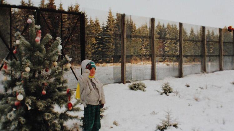 Der damals fünfjährige Daniel Greiner am Weihnachtsbaum vor dem Metallgitterzaun auf DDR-Gebiet