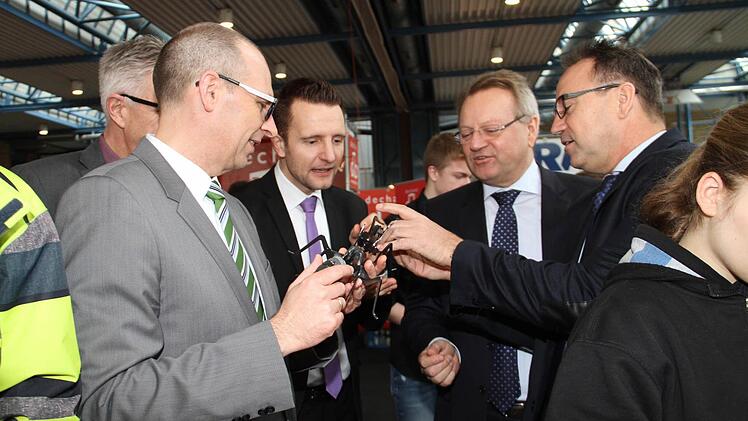 (v. li.) Schulleiter Hans-Jürgen Lichy, Landrat Christian Meißner und Bürgermeister Andreas Hügerich lassen sich von Günter und Robert Hofmann, von der Unternehmensgruppe Hofmann die Funktionsweise eines Insektes erklären, das die jungen Leute zusammenbauen konnten.