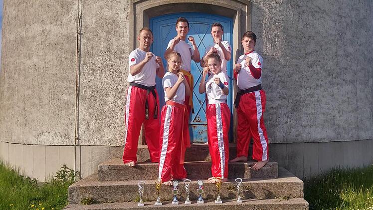 Power und Pokale vor dem Wasserturm: Unser Bild zeigt das Martial-Arts-Team des TSV Rannungen mit (hinten, von links) Holger Volz, Sandro Neumann, Kai Heimann und Nils Volz sowie (vorne, von links) Rebekka Anderson und Julia Zehner. Foto: privat